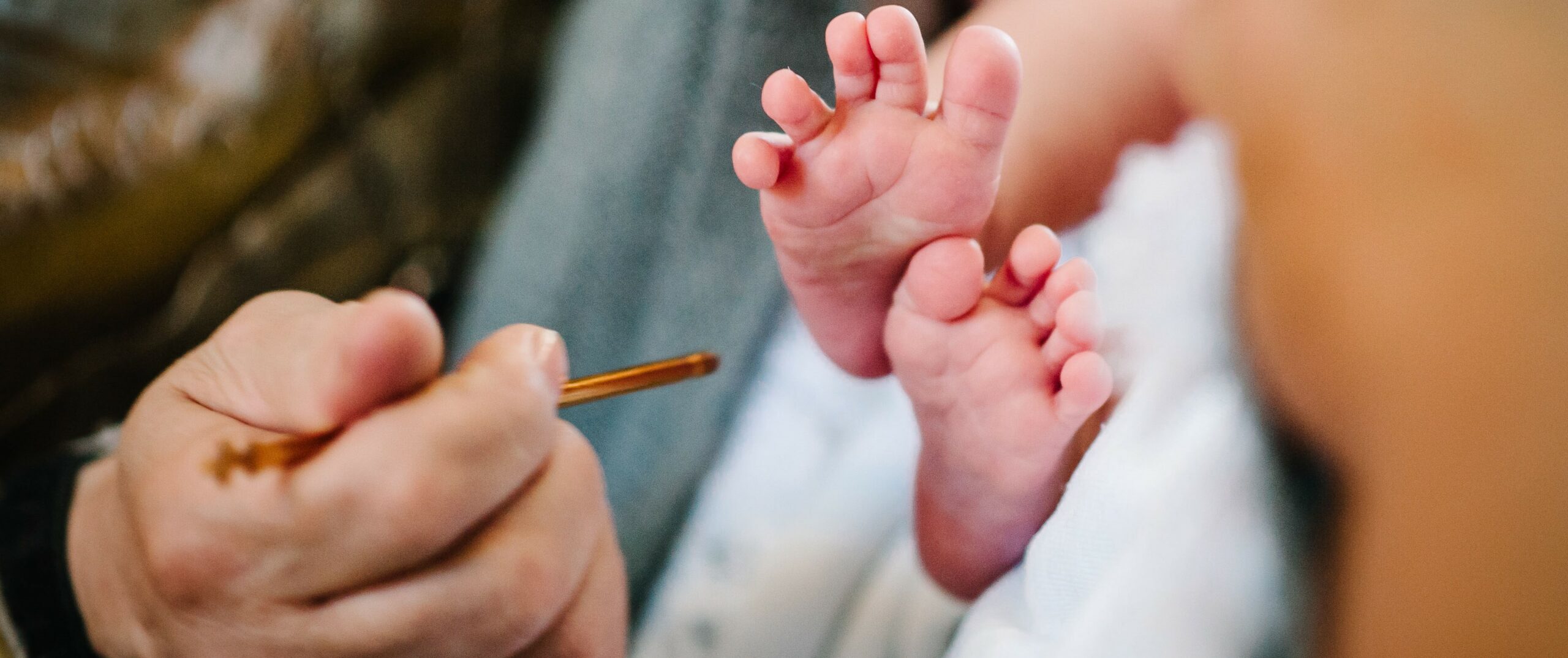 Pfarrer macht Kreuz auf kindes Fuss