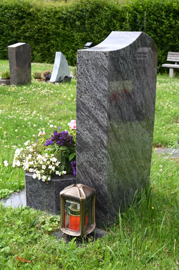 Pflegeleichtes Grab mit Granitstein und Blumentopf davor